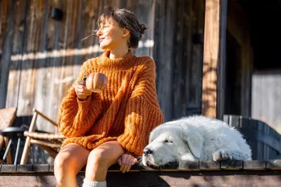 woman and dog on cabin porch