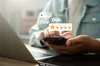 Person reading reviews on phone and laptop