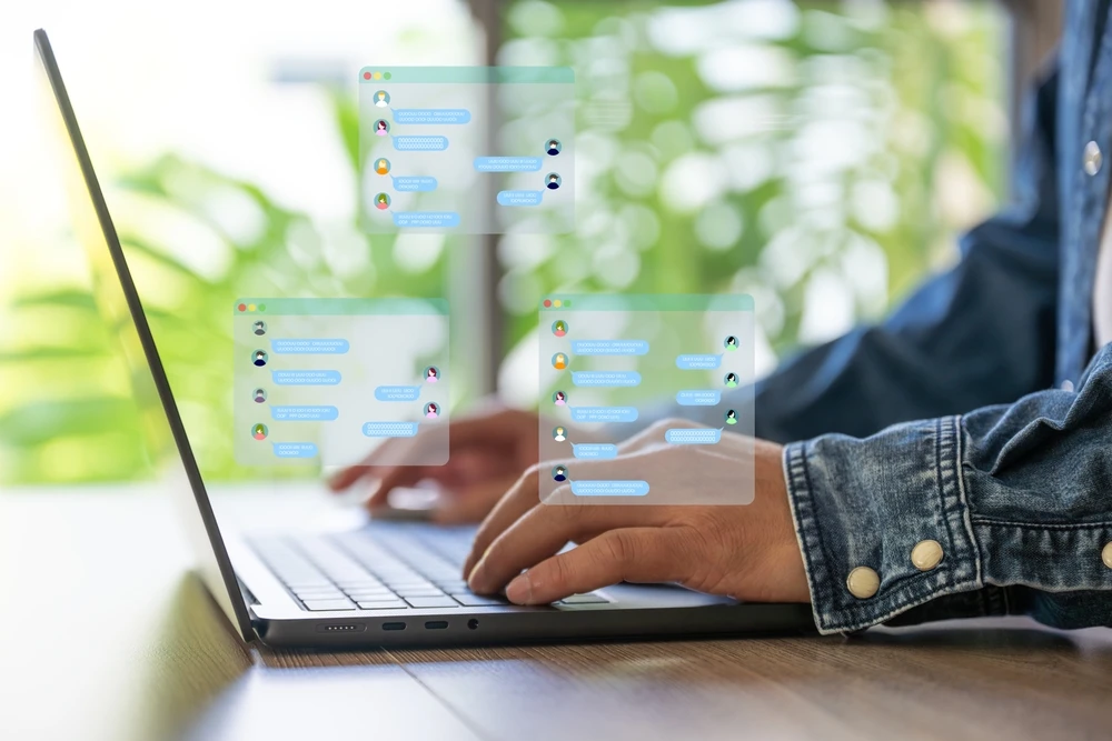 man messaging people on laptop