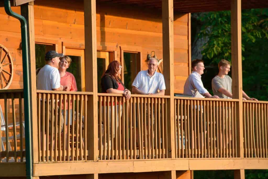 people standing on the deck of a smoky mountain cabin