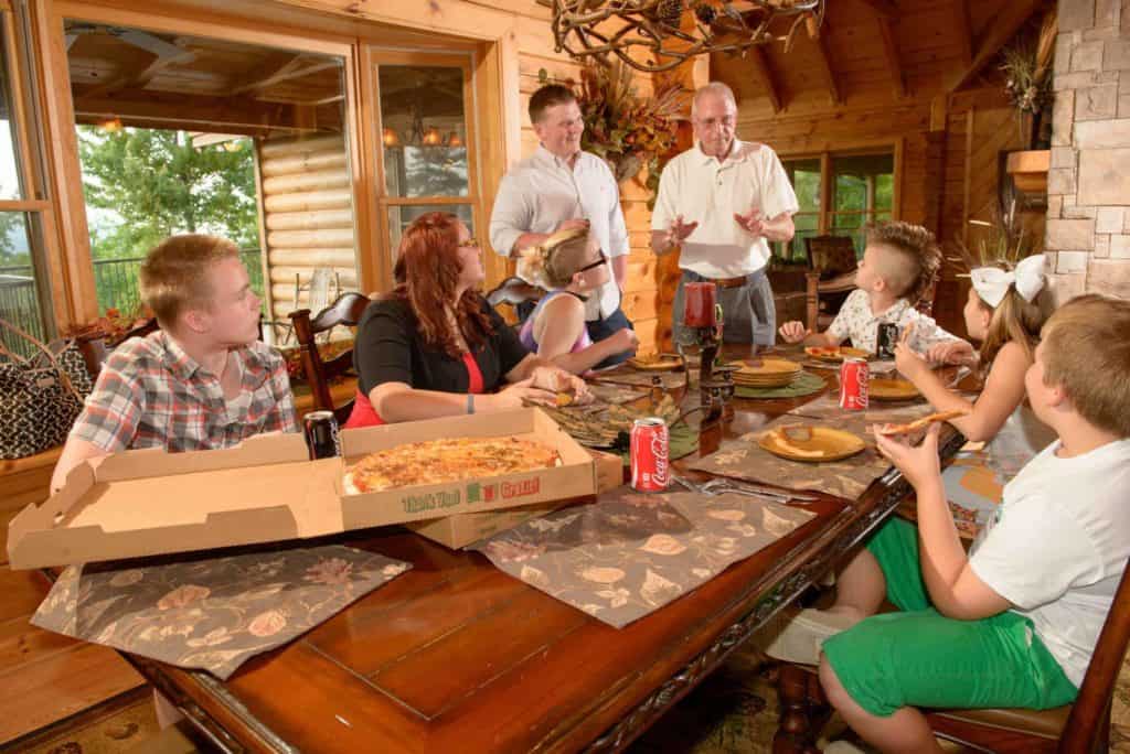 family eating pizza in their cabin rental