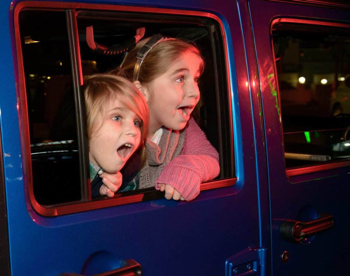 kids looking out the side of a jeep